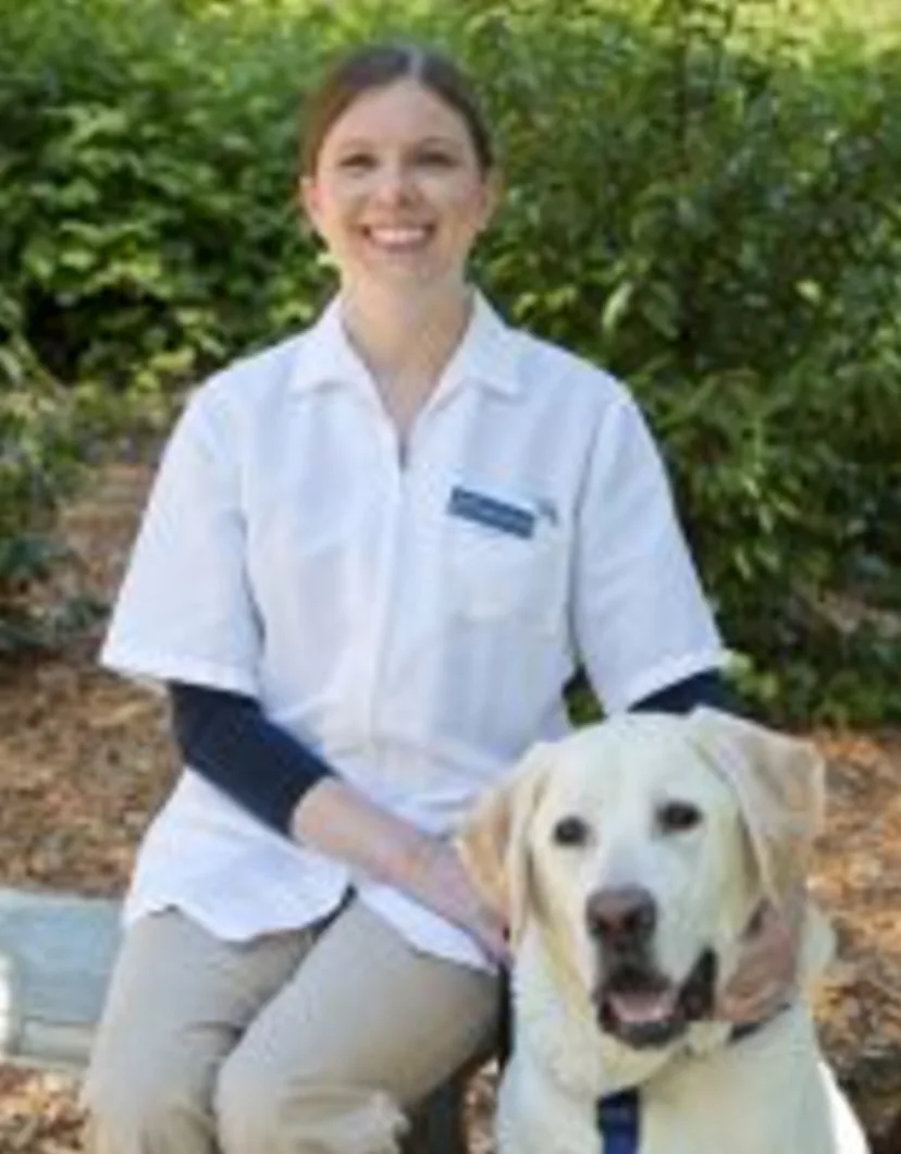 Dr. Stephanie Smiling & Sitting Next to Dog